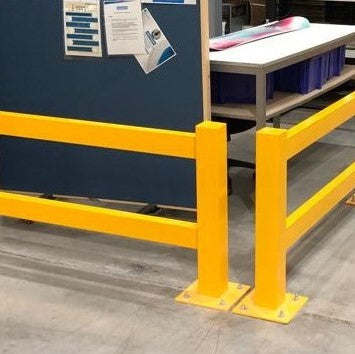 Barrera metálica protegiendo un rack en una zona de trabajo